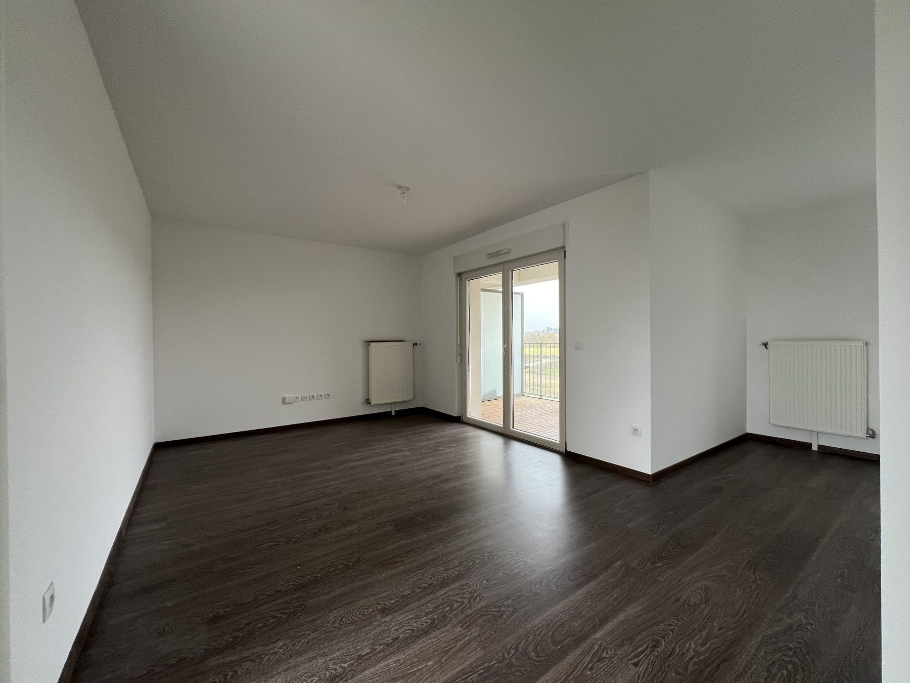 Pièce blanche au parquet foncé